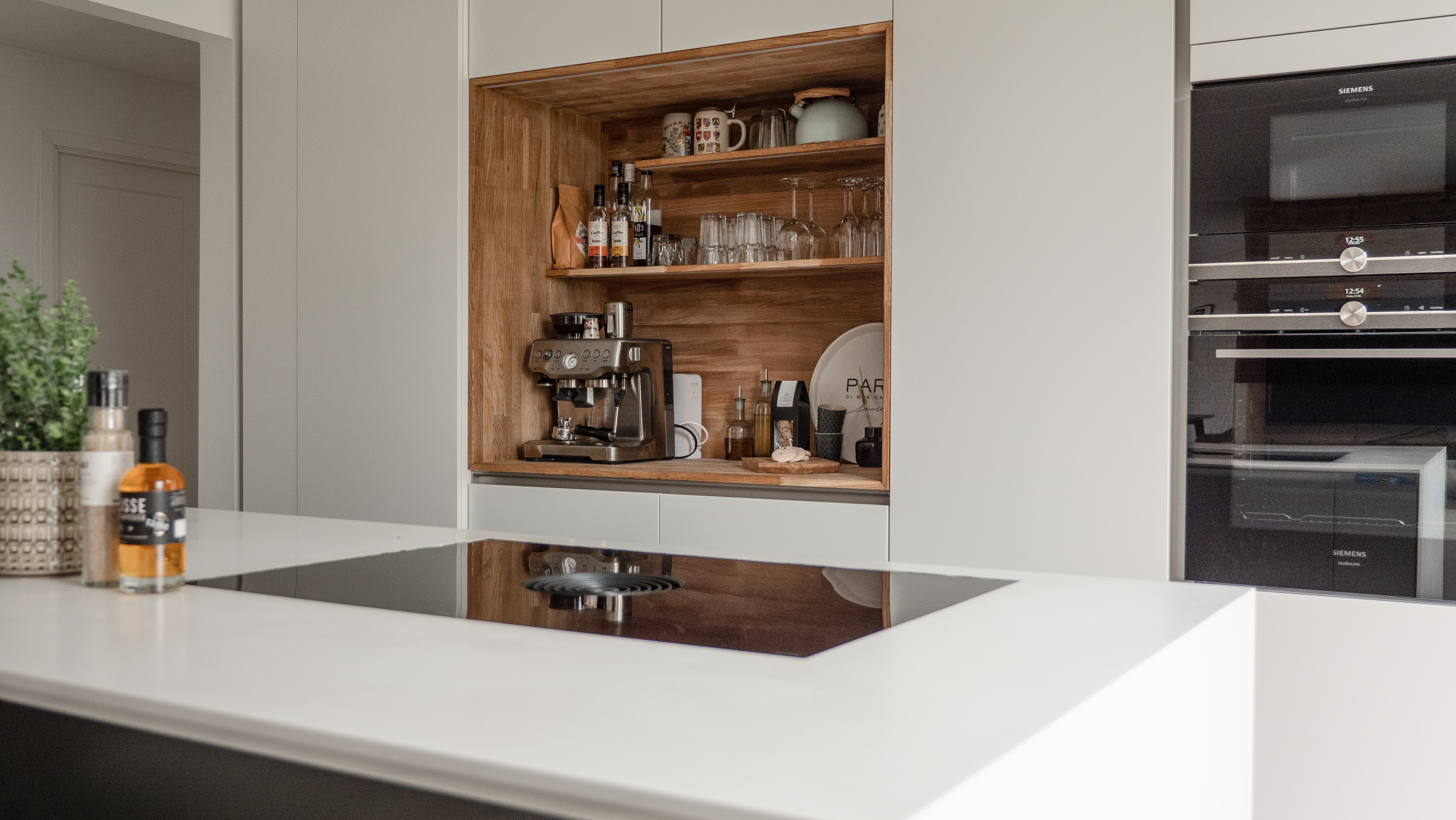 Oak coffee and drinks station built into a handleless kitchen
